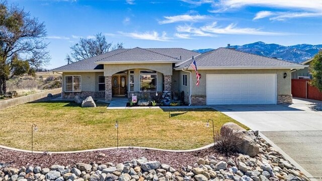 22104 Mccarthy Dr, Tehachapi, CA 93561 - single story home featuring stucco siding, a garage, stone siding, concrete driveway, and a mountain view