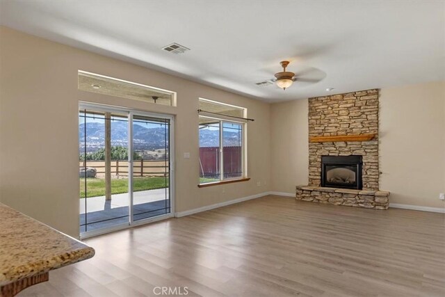 22104 Mccarthy Dr, Tehachapi, CA 93561 - unfurnished living room with wood finished floors, a ceiling fan, a fireplace, and baseboards