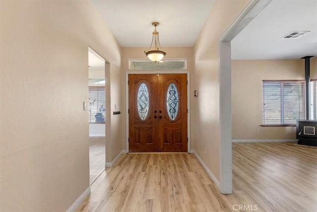 22104 Mccarthy Dr, Tehachapi, CA 93561 - entryway with light wood-style flooring, baseboards, and a wood stove
