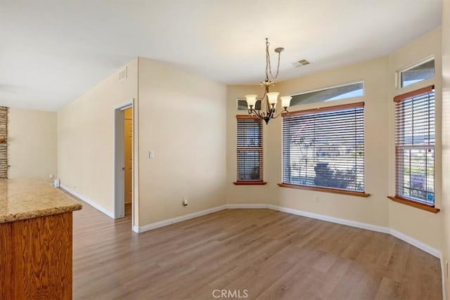 22104 Mccarthy Dr, Tehachapi, CA 93561 - unfurnished dining area featuring light wood-style flooring, a chandelier, and baseboards