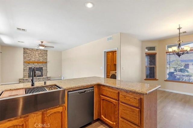 22104 Mccarthy Dr, Tehachapi, CA 93561 - kitchen with stainless steel dishwasher, a sink, a fireplace, ceiling fan, and light wood finished floors