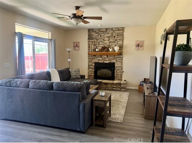 22104 Mccarthy Dr, Tehachapi, CA 93561 - living area with a ceiling fan, wood finished floors, and a stone fireplace