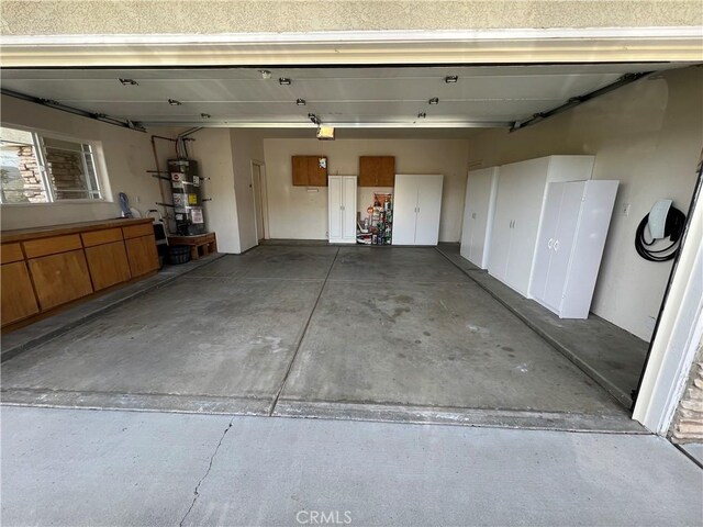 22104 Mccarthy Dr, Tehachapi, CA 93561 - garage with strapped water heater and a garage door opener