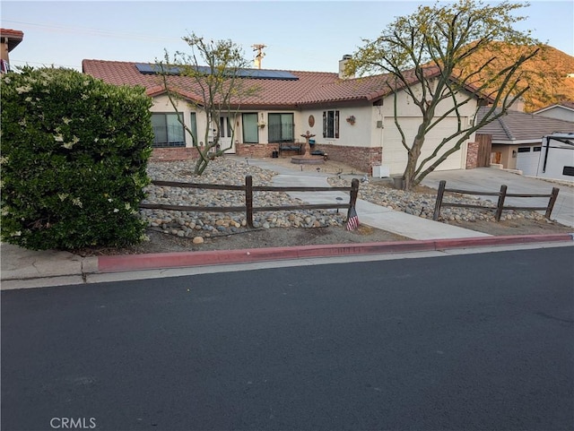 23040 Giant Fir Pl, Canyon Lake, CA 92587 - view of front of house with a garage, a chimney, a tiled roof, roof mounted solar panels, and concrete driveway