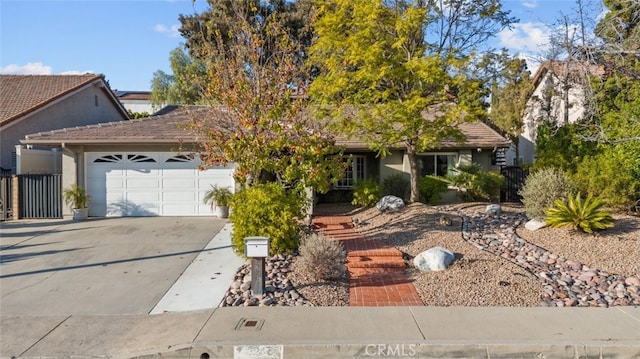 13247 Mission Tierra Way, Granada Hills, CA 91344 - view of front of house featuring an attached garage, concrete driveway, stucco siding, and a tile roof