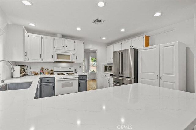 13247 Mission Tierra Way, Granada Hills, CA 91344 - kitchen with white appliances, a sink, light stone countertops, recessed lighting, and white cabinetry