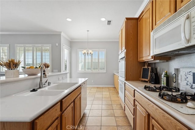 10237 Cotoneaster St, Apple Valley, CA 92308 - kitchen featuring white appliances, a sink, brown cabinetry, healthy amount of natural light, and crown molding