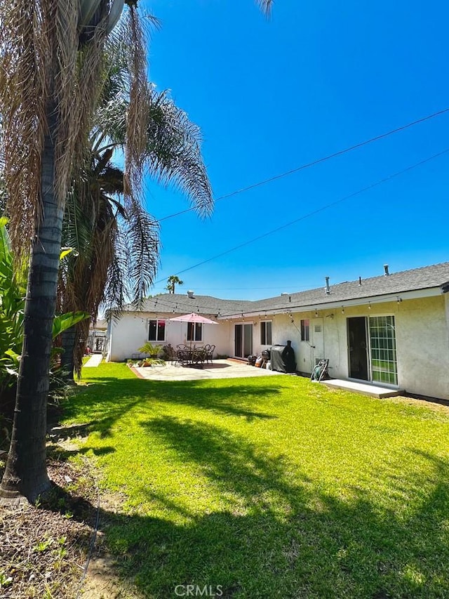 4036 N Foxdale Ave, Covina, CA 91722 - rear view of house featuring stucco siding, a patio, and a lawn