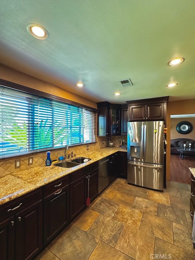 4036 N Foxdale Ave, Covina, CA 91722 - kitchen with stainless steel appliances, a sink, decorative backsplash, light stone counters, and glass insert cabinets
