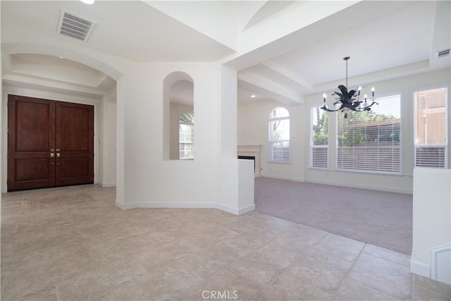 583 Ruth Cir, Corona, CA 92879 - empty room featuring a chandelier, a tray ceiling, light colored carpet, baseboards, and a fireplace