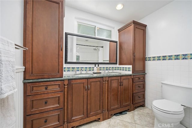 2704 Albatross Dr, Costa Mesa, CA 92626 - bathroom featuring double vanity, tile walls, toilet, tile patterned flooring, and a wainscoted wall