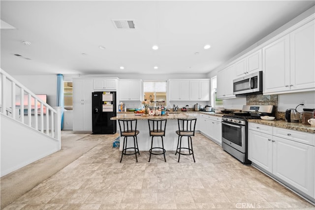 5874 Silver Oaks Dr, Chino, CA 91710 - kitchen featuring appliances with stainless steel finishes, a breakfast bar, a center island, white cabinets, and recessed lighting