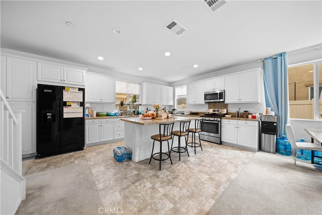 5874 Silver Oaks Dr, Chino, CA 91710 - kitchen featuring appliances with stainless steel finishes, a kitchen bar, white cabinets, a center island, and recessed lighting