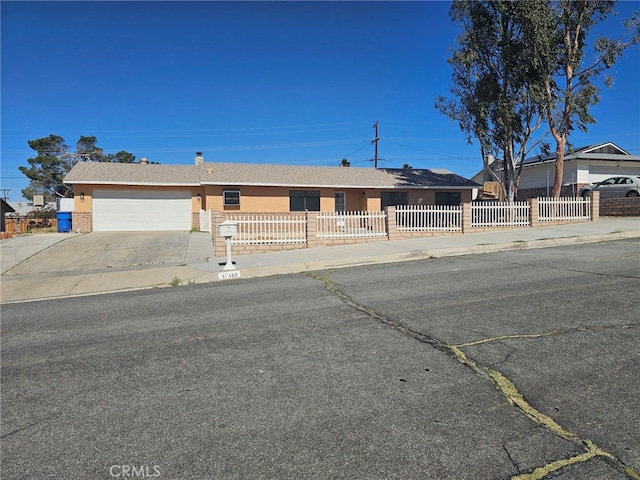 37146 Lombardy Ave, Barstow, CA 92311 - ranch-style house with a fenced front yard, a garage, concrete driveway, and stucco siding
