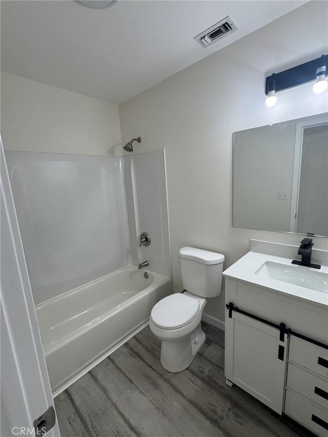 37146 Lombardy Ave, Barstow, CA 92311 - bathroom featuring wood finished floors, toilet, vanity, and washtub / shower combination