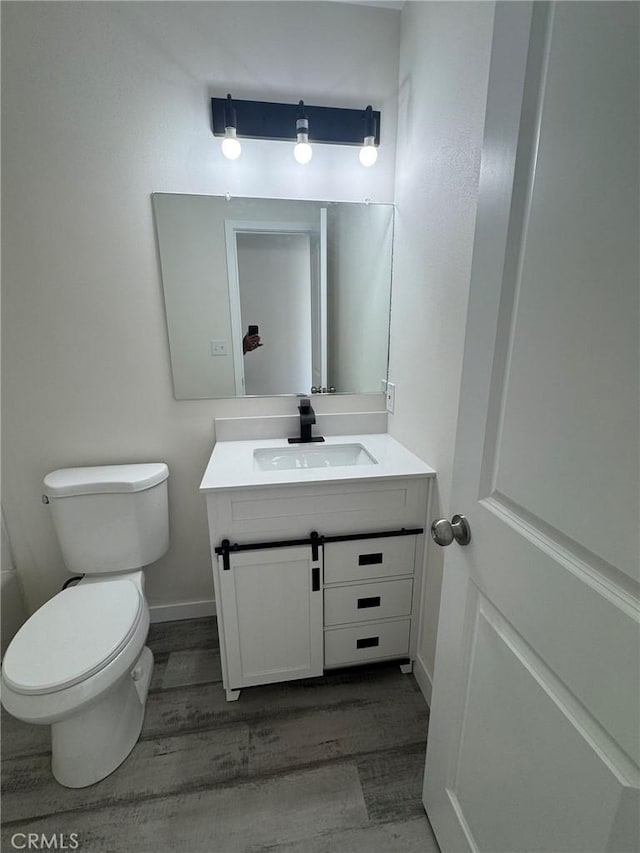 37146 Lombardy Ave, Barstow, CA 92311 - bathroom featuring vanity, toilet, wood finished floors, and baseboards