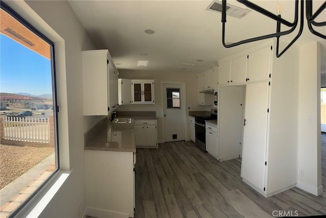 37146 Lombardy Ave, Barstow, CA 92311 - kitchen with stainless steel range with electric stovetop, healthy amount of natural light, and white cabinetry