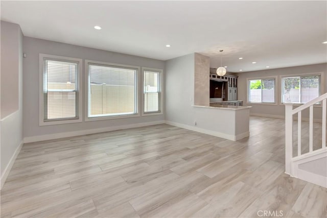 26242 Via Corrizo, San Juan Capistrano, CA 92675 - unfurnished living room featuring baseboards, recessed lighting, light wood-style floors, and stairway