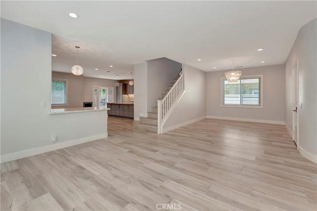 26242 Via Corrizo, San Juan Capistrano, CA 92675 - unfurnished living room featuring a chandelier, recessed lighting, stairway, baseboards, and light wood finished floors