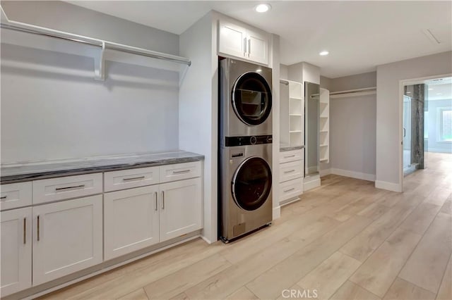 26242 Via Corrizo, San Juan Capistrano, CA 92675 - washroom featuring stacked washer / dryer, light wood-type flooring, recessed lighting, baseboards, and cabinet space