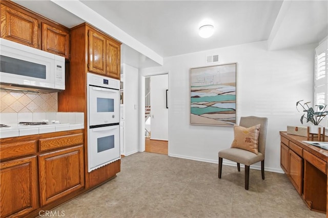 3441 Lilly Ave, Long Beach, CA 90808 - kitchen featuring white appliances, brown cabinets, decorative backsplash, tile counters, and baseboards
