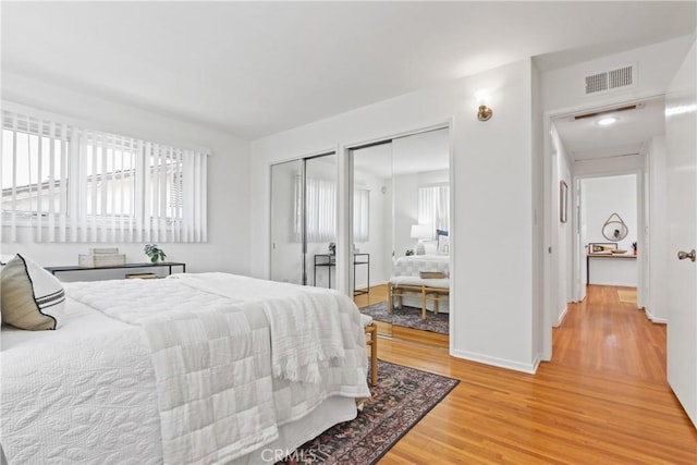 3441 Lilly Ave, Long Beach, CA 90808 - bedroom with two closets, multiple windows, light wood finished floors, and baseboards