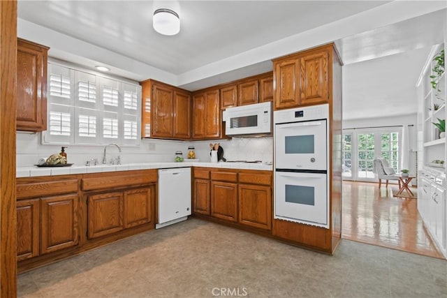 3441 Lilly Ave, Long Beach, CA 90808 - kitchen featuring white appliances, brown cabinets, a sink, and backsplash