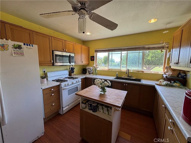 10265 Nancy Ave, Cherry Valley, CA 92223 - kitchen with white appliances, a sink, dark wood finished floors, ceiling fan, and brown cabinetry