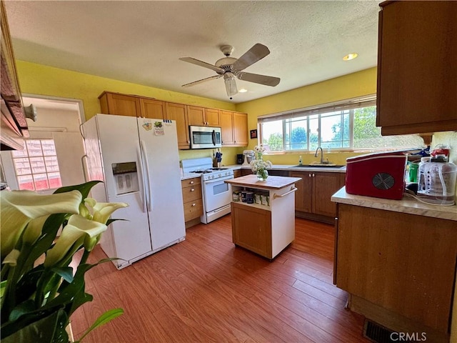 10265 Nancy Ave, Cherry Valley, CA 92223 - kitchen featuring white appliances, a sink, a ceiling fan, wood finished floors, and a kitchen island