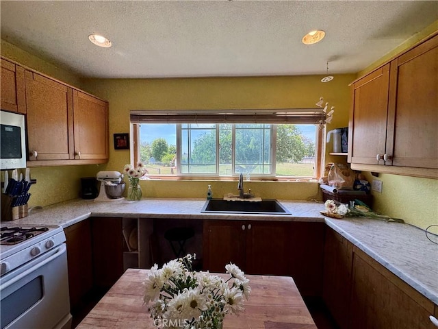 10265 Nancy Ave, Cherry Valley, CA 92223 - kitchen with a sink, stainless steel microwave, plenty of natural light, white gas range oven, and a textured ceiling