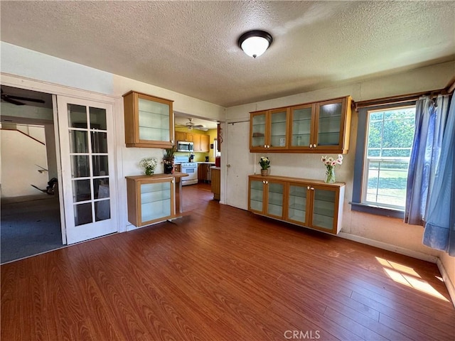 10265 Nancy Ave, Cherry Valley, CA 92223 - unfurnished living room featuring a textured ceiling, dark wood finished floors, ceiling fan, and baseboards