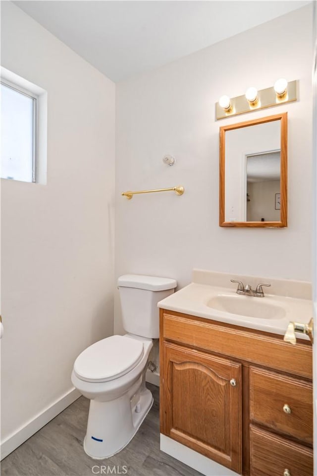 24438 Sage Ave, Boron, CA 93516 - half bathroom featuring wood finished floors, vanity, toilet, and baseboards
