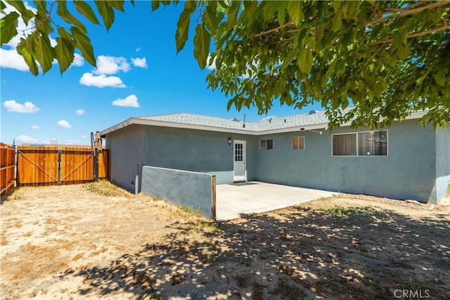 24438 Sage Ave, Boron, CA 93516 - back of property featuring stucco siding, a patio, and a gate