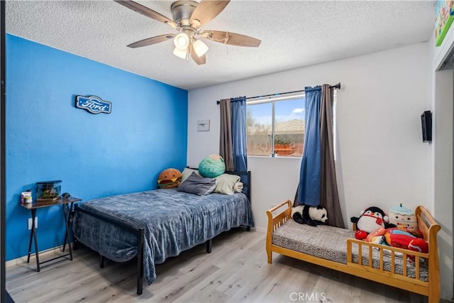 24438 Sage Ave, Boron, CA 93516 - bedroom featuring wood finished floors, a textured ceiling, a ceiling fan, and baseboards