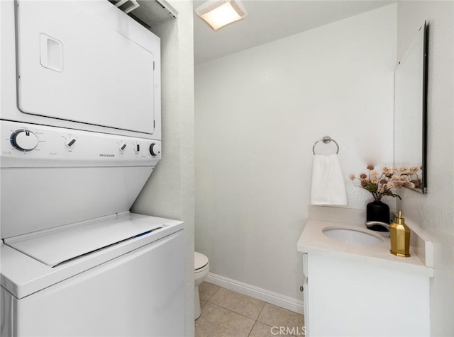 222 S Catalina Ave Unit 8, Pasadena, CA 91106 - half bath with stacked washing machine and dryer, vanity, tile patterned floors, toilet, and baseboards