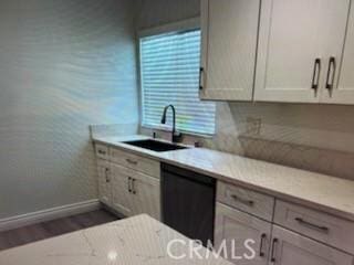 850 N Kathleen Ln, Orange, CA 92867 - kitchen featuring black dishwasher, a sink, baseboards, wood finished floors, and light stone counters