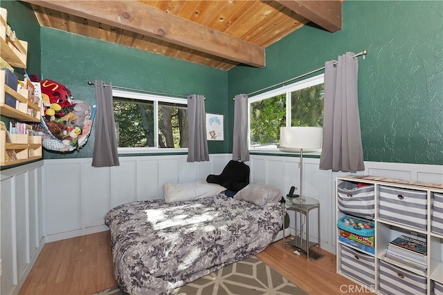 197 Weisshorn Dr, Crestline, CA 92325 - bedroom featuring wood ceiling with exposed beams, wood finished floors, a wainscoted wall, a decorative wall, and a textured wall