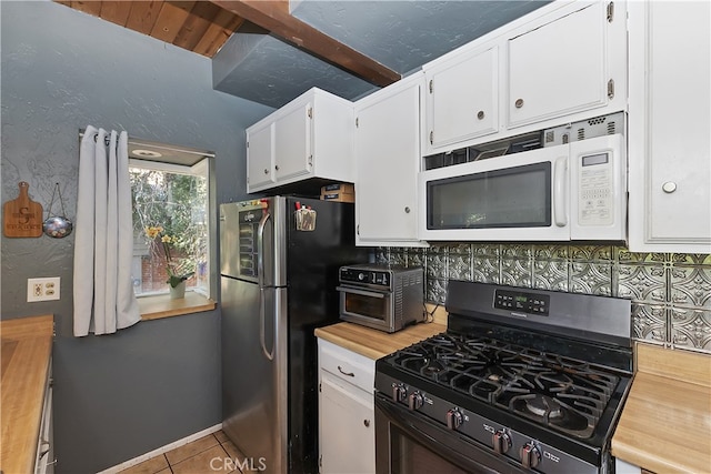 197 Weisshorn Dr, Crestline, CA 92325 - kitchen with white microwave, range with gas stovetop, freestanding refrigerator, white cabinetry, and tile patterned flooring