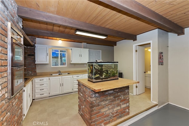 197 Weisshorn Dr, Crestline, CA 92325 - kitchen with wooden counters, wooden ceiling with exposed beams, white cabinets, a sink, and double oven