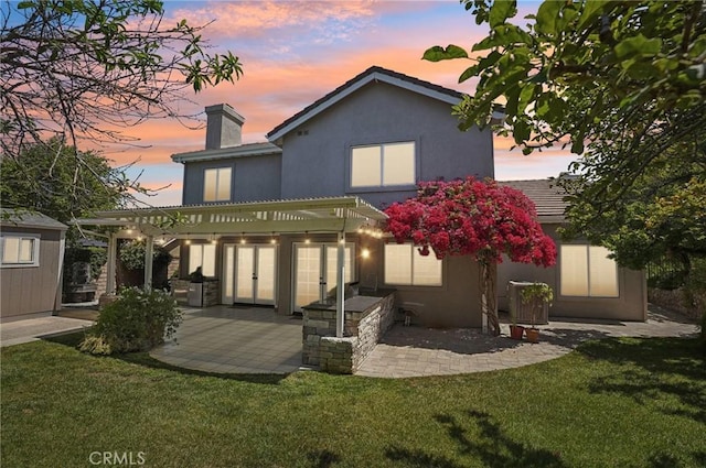 3184 Holloway Ct, Newbury Park, CA 91320 - back of house at dusk featuring a pergola, a chimney, a patio area, and a yard