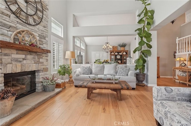 3184 Holloway Ct, Newbury Park, CA 91320 - living room with a towering ceiling, plenty of natural light, a stone fireplace, a chandelier, and wood finished floors