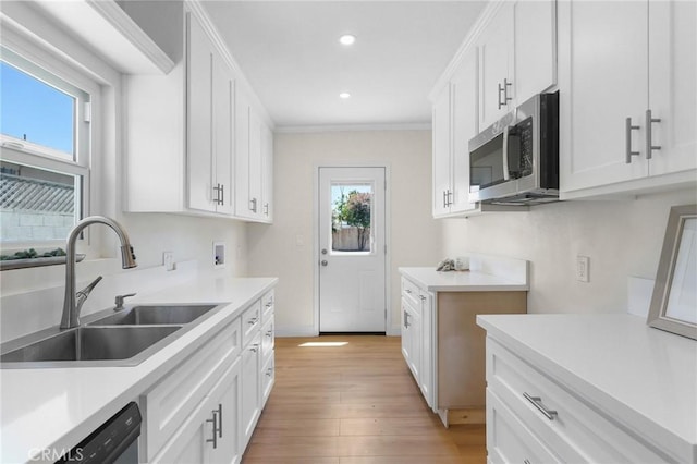208 W Caldwell St, Compton, CA 90220 - kitchen with stainless steel microwave, a sink, dishwasher, light wood-style floors, and white cabinetry