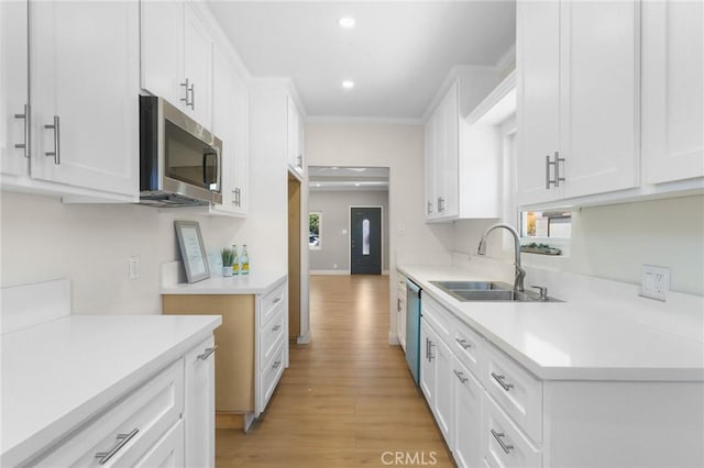 208 W Caldwell St, Compton, CA 90220 - kitchen with stainless steel appliances, light wood-style flooring, white cabinets, recessed lighting, and light countertops