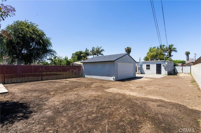 208 W Caldwell St, Compton, CA 90220 - back of house with a fenced backyard, a garage, and an outdoor structure