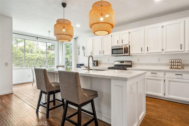 27636 Brentstone Way, Murrieta, CA 92563 - kitchen with appliances with stainless steel finishes, a sink, white cabinets, recessed lighting, and an island with sink