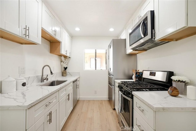 14803 Vanowen St Unit 9, Van Nuys, CA 91405 - kitchen with stainless steel appliances, light wood-style flooring, a sink, baseboards, and recessed lighting
