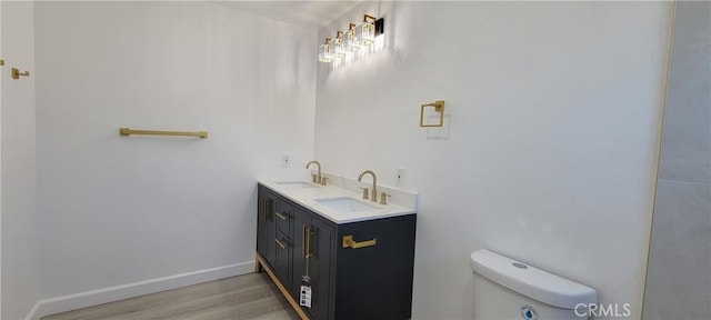 3355 Debbie Ln, Riverside, CA 92501 - bathroom with toilet, wood finished floors, double vanity, and baseboards