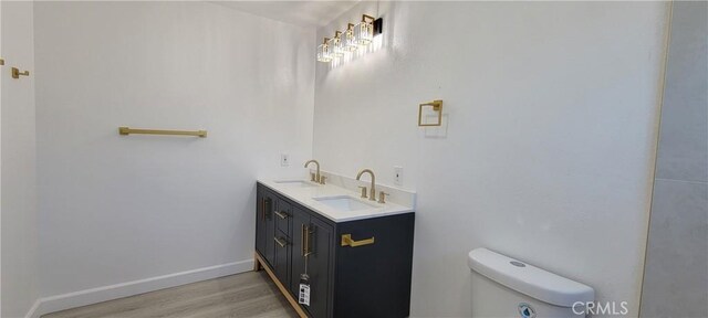 3355 Debbie Ln, Riverside, CA 92501 - bathroom with toilet, wood finished floors, double vanity, and baseboards
