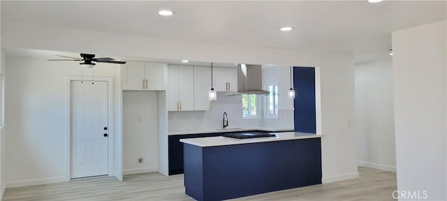 3355 Debbie Ln, Riverside, CA 92501 - kitchen with range hood, a ceiling fan, a sink, light countertops, and light wood finished floors