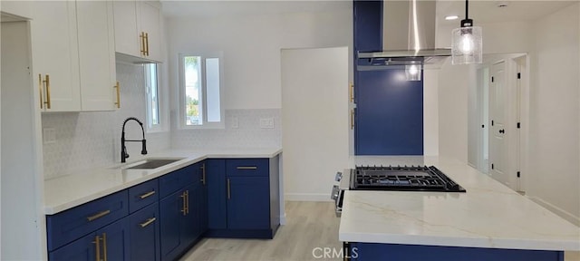 3355 Debbie Ln, Riverside, CA 92501 - kitchen with a sink, wall chimney exhaust hood, blue cabinets, and light wood-type flooring
